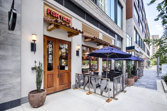 a restaurant with a wooden door and patio umbrellas