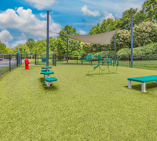 A park with a green lawn and a red fire hydrant.