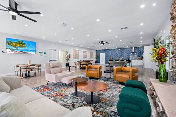 A living room with a large flat screen TV mounted on the wall.