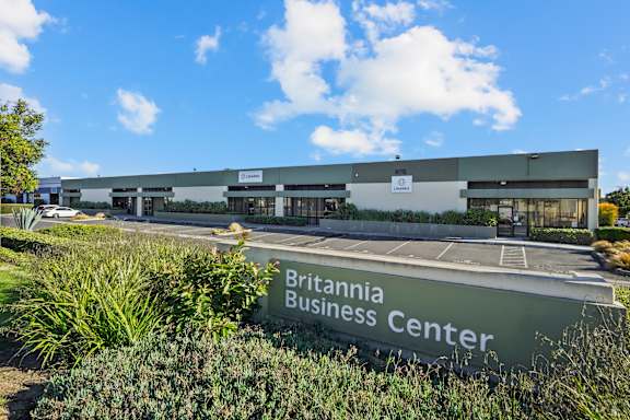 The Britannia Business Center is a large, modern building with a parking lot in front.