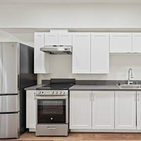 A modern kitchen with white cabinets and stainless steel appliances.