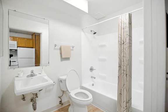 A white toilet sits next to a sink in a bathroom.