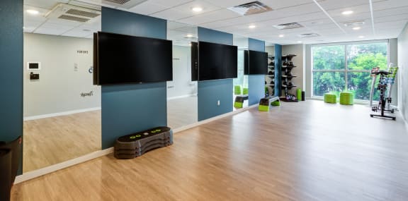 a large room with a wood floor and large flat screen televisions on the wall