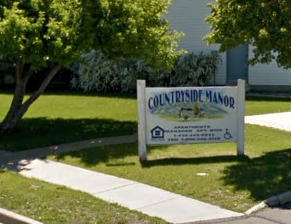 A sign for Coltridside Manor in front of a tree.