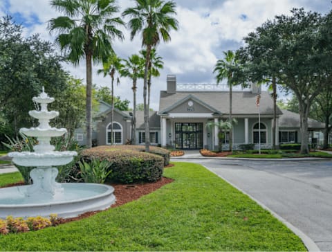 Leasing office exterior with water fountain feature surrounded by native landscaping