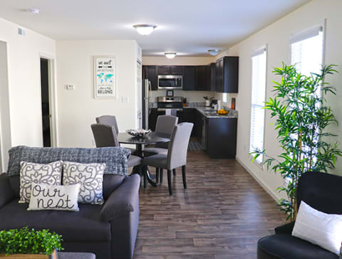 a living room with a couch and a table and a kitchen at Promenade at New Town, Missouri, 63301