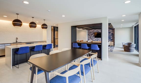 a dining room with blue chairs and a long table
