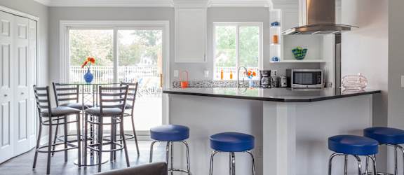 A kitchen with a bar area and a dining table.