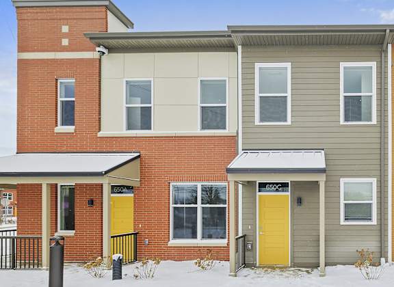 a house with yellow doors in the snow