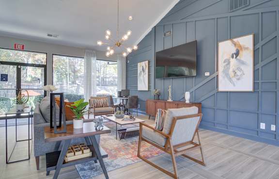 A living room with a white couch, a coffee table, and a painting on the wall.