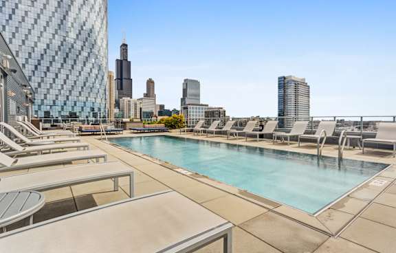 A pool area with a view of the city skyline.