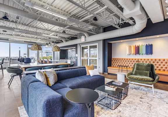 A blue couch with a black table in front of it.