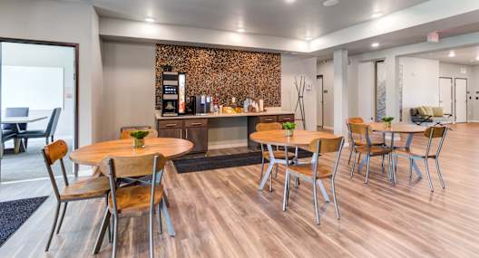 a common area with tables and chairs and a coffee bar