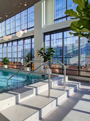 A large indoor swimming pool with a sunken seating area.