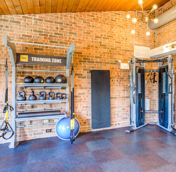 the home gym has plenty of racks of weights and dumbbells