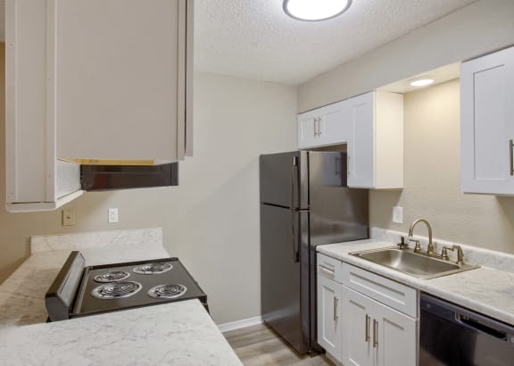 a kitchen with white cabinets and a granite counter top