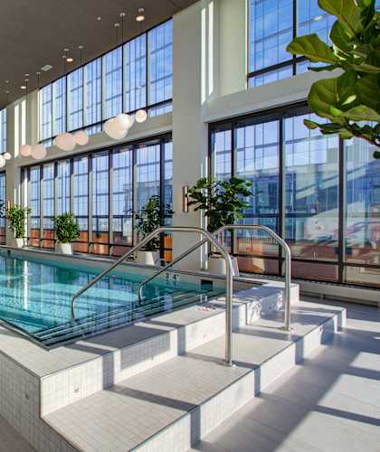 A large indoor swimming pool with a sunken seating area.