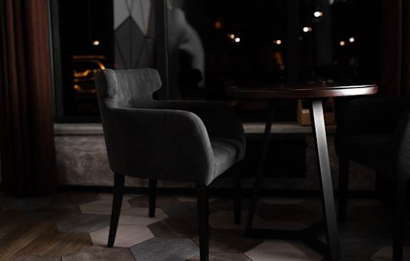 A chair and table are in a dark room.