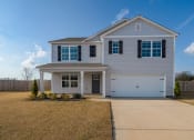Thumbnail 2 of 6 - a white house with a driveway and a garage door