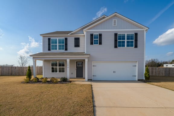 a white house with a driveway and a garage door