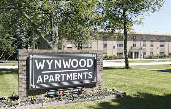 A sign for Wynwood Apartments is displayed in front of a building.