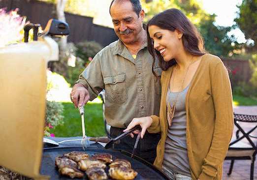 a man and a woman cooking food on a grill