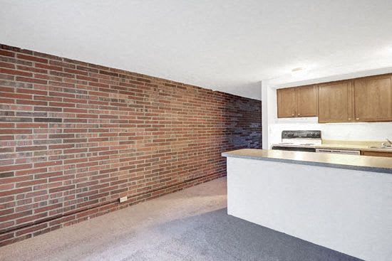 a kitchen with a brick wall and a white counter top