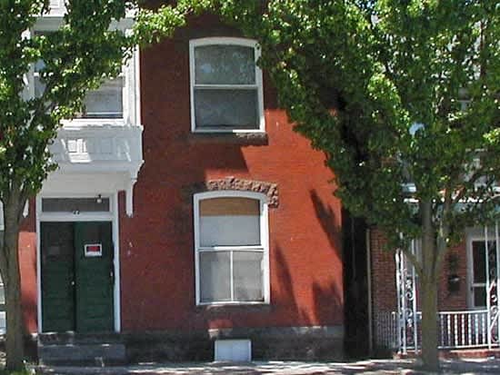 a red brick house with a tree in front of it