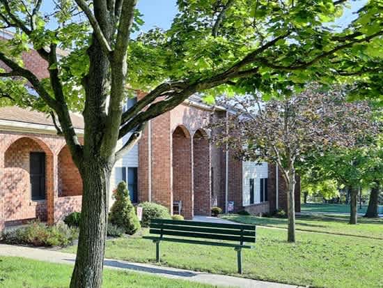 a park bench in front of a brick building