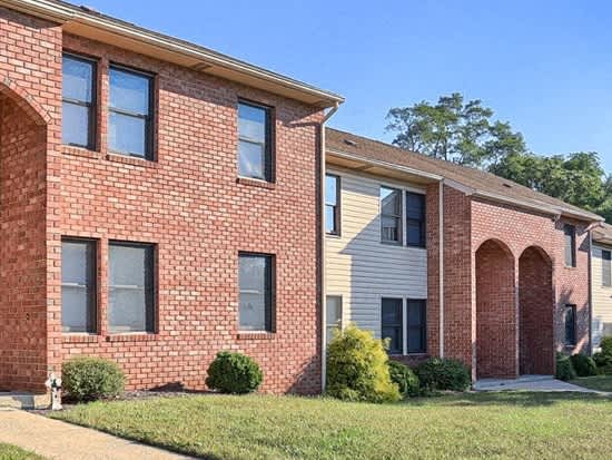 a brick house with a sidewalk in front of it