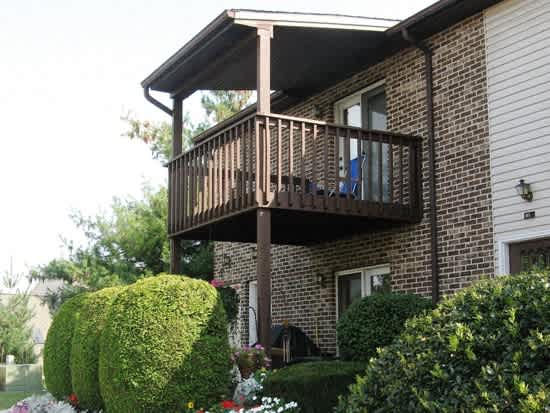 a balcony on the side of a brick house