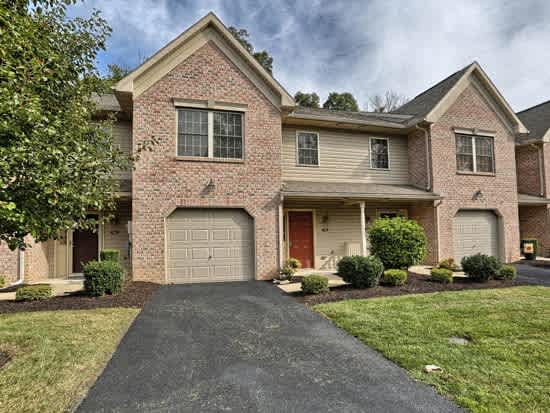 a brick house with a garage door on a driveway