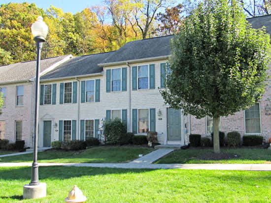a white house with a tree and a lamp post