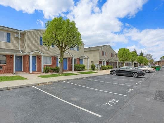 an empty parking lot in front of a row of houses