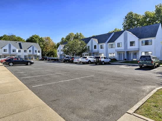 a parking lot with cars parked in front of houses