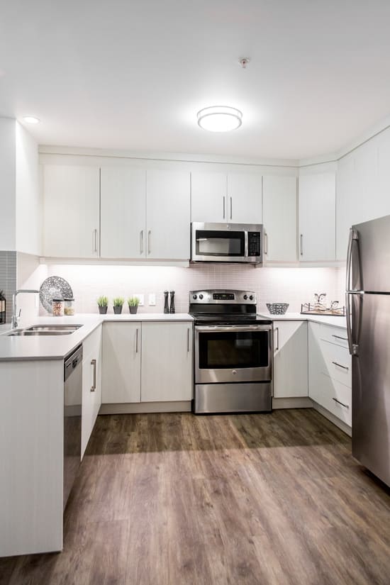 a kitchen with white cabinets and stainless steel appliances