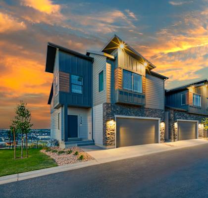 a row of houses with garage doors at sunset