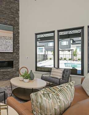 A modern kitchen with a stone fireplace and a dining area with a table and chairs.