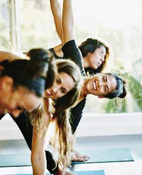 a group of people doing yoga in a room