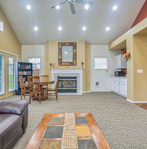 A living room with a brown leather couch and a fireplace.