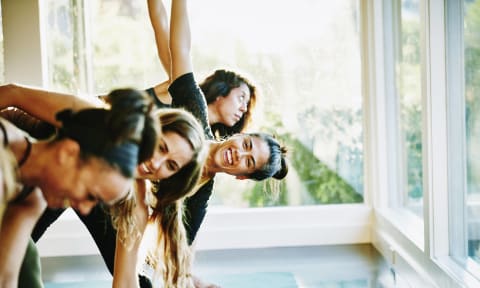 a group of people doing yoga in a room