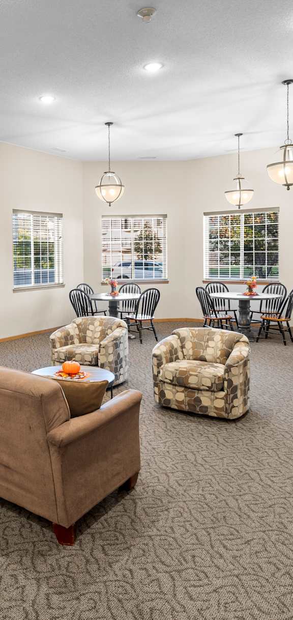 A living room with a couch, chairs, and a television.