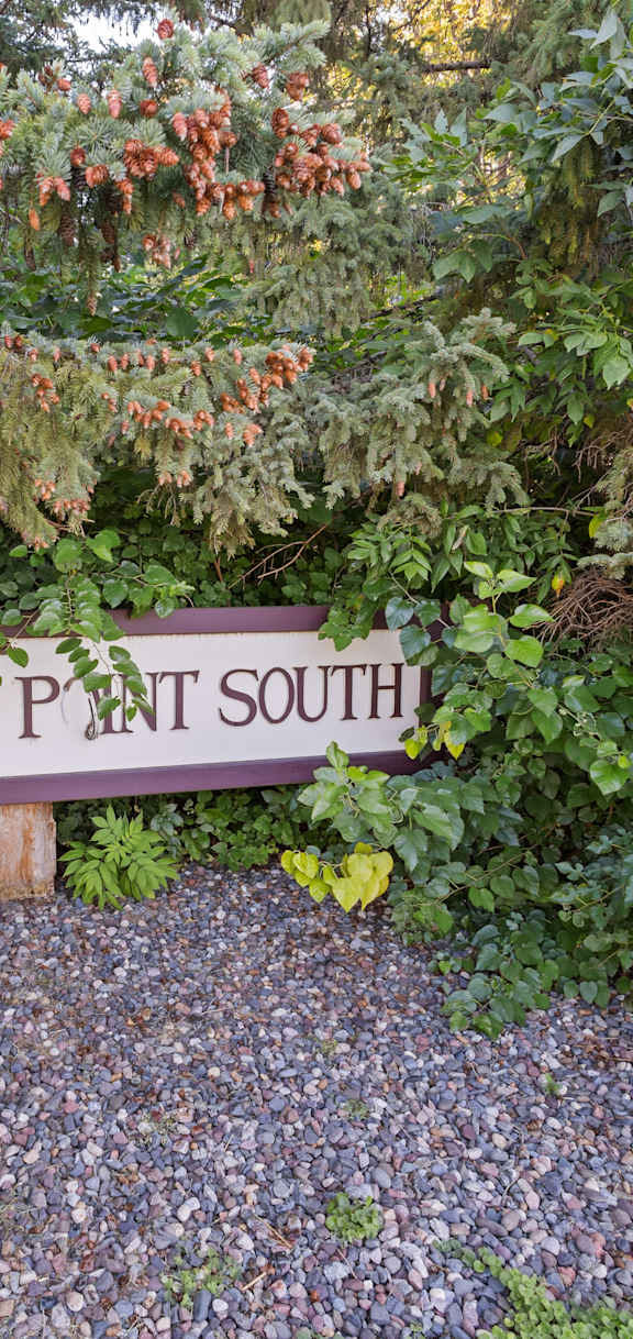 a sign for lake path south in front of some trees