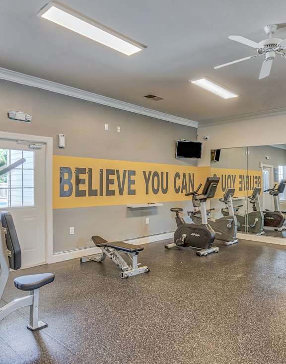 A gym with a sign that says "Believe You Can" on the wall.
