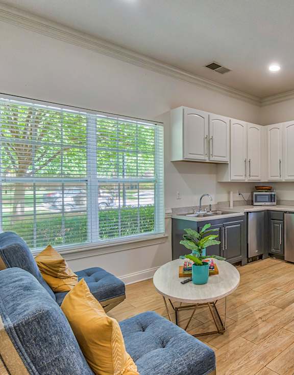 A living room with a blue couch and a white coffee table.