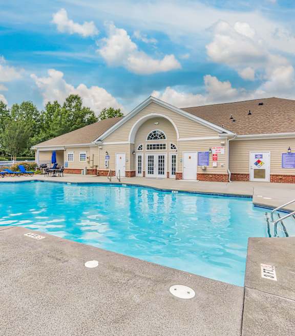 A large outdoor swimming pool with a building in the background.