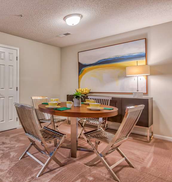A dining room with a table set for four.