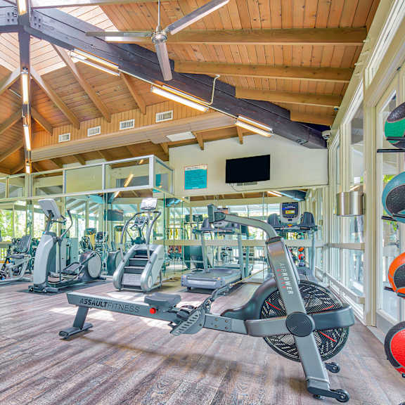 A gym with a variety of equipment including treadmills, weights and exercise machines.