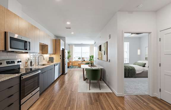 an open kitchen and dining area with a bedroom in the background