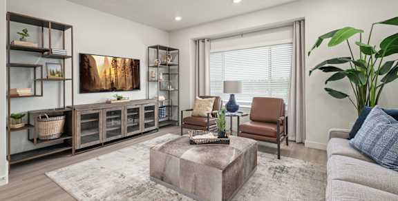 A living room with a brown coffee table and a grey couch.